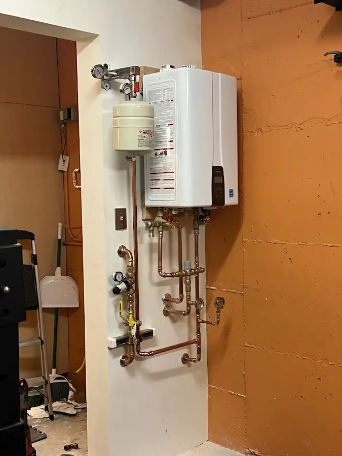 Plumbing technician inspecting water heater connections in Bainbridge